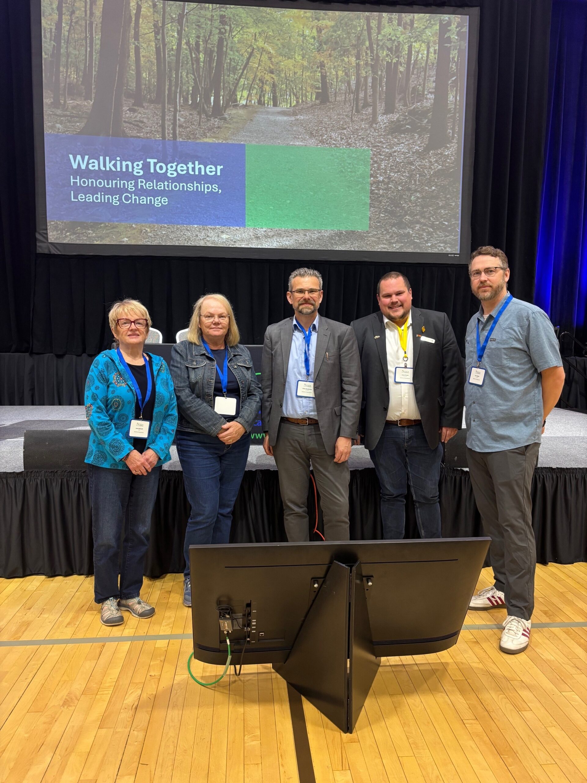 Mayor Joan Atkinson, Councillors Raye McMeeken, VIktor Brumovsky, Jesse Wright and Kyle Tapper stand together for a photo in an auditorium.