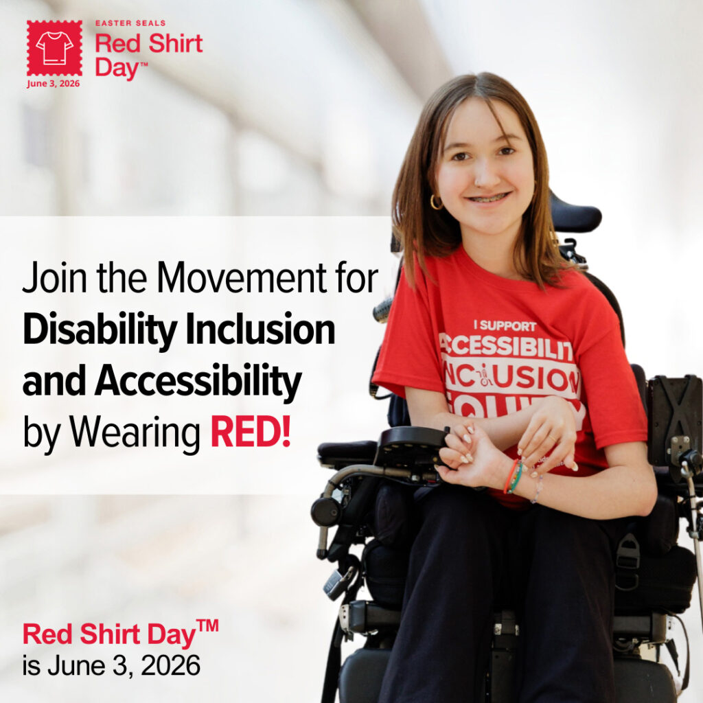 a young girl in a red shirt smiles in her mobility chair