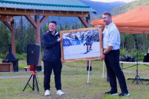 Evan Bichon and Deputy Mayor Kyle Tapper hold a framed photo of Evan snowboarding