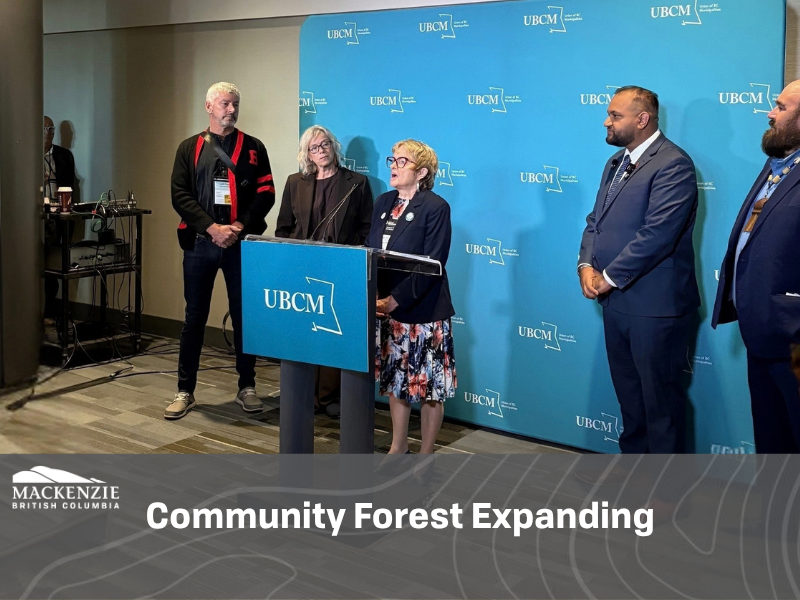 Mayor Joan Atkinson stands at a podium with Honourable Ravi Parmar