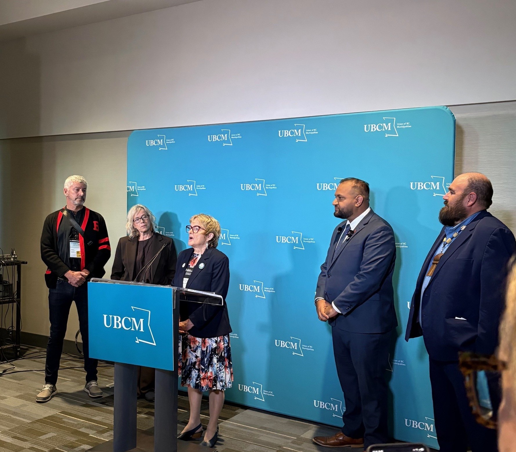Mayor Joan Atkinson stands at a podium with honourable Ravi Parmar